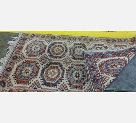 (10) Tapis oriental teinte orange et crème. 130/75 cm