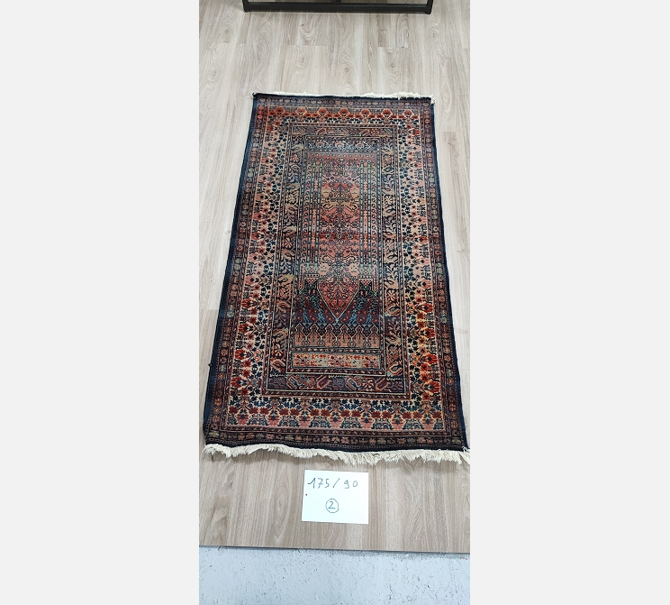 (2) Tapis oriental teintes noir rouge. 175/90 cm. 1 coupure