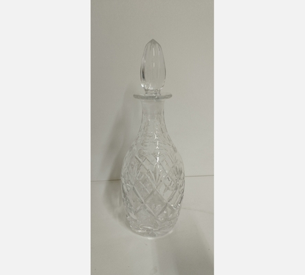 Carafe en cristal ciselé de forme allongée avec bouchon.