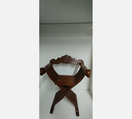 Fauteuil pliant Dagobert Curule en bois sculpté.
