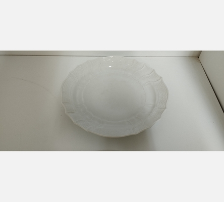 Grand plat rond en porcelaine blanche, décor en relief.