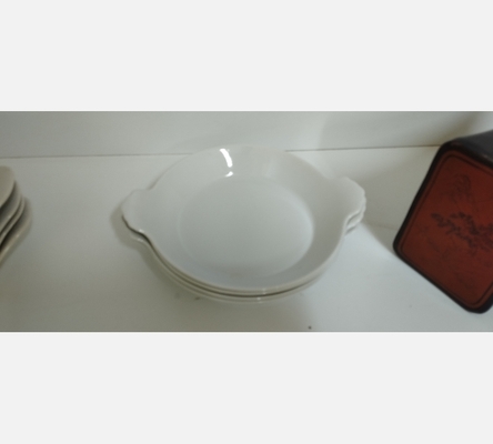 Lot de 4 assiettes creuses à oreilles en céramique blanche.