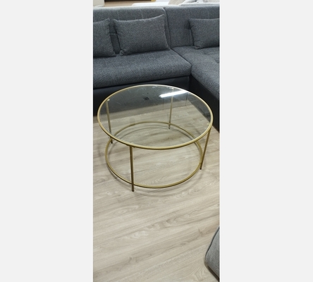 Table basse ronde dorée dessus verre.